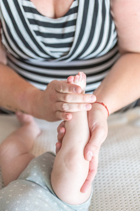 Deandra massaging a baby's foot.