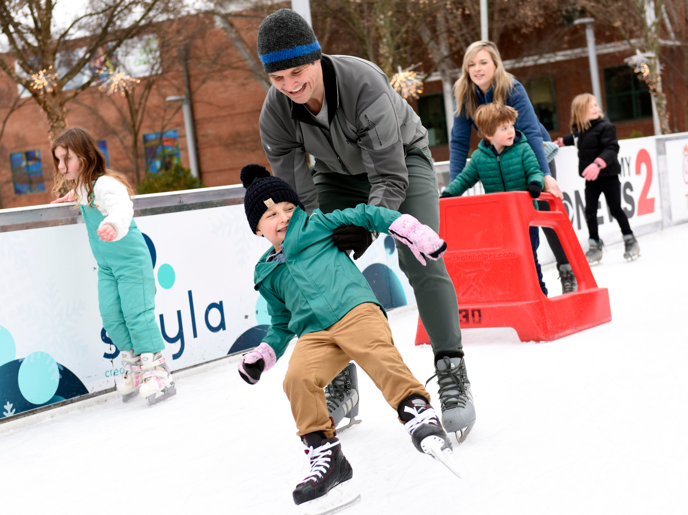 Photo of a Friendly father and his son ice skating in 2025.